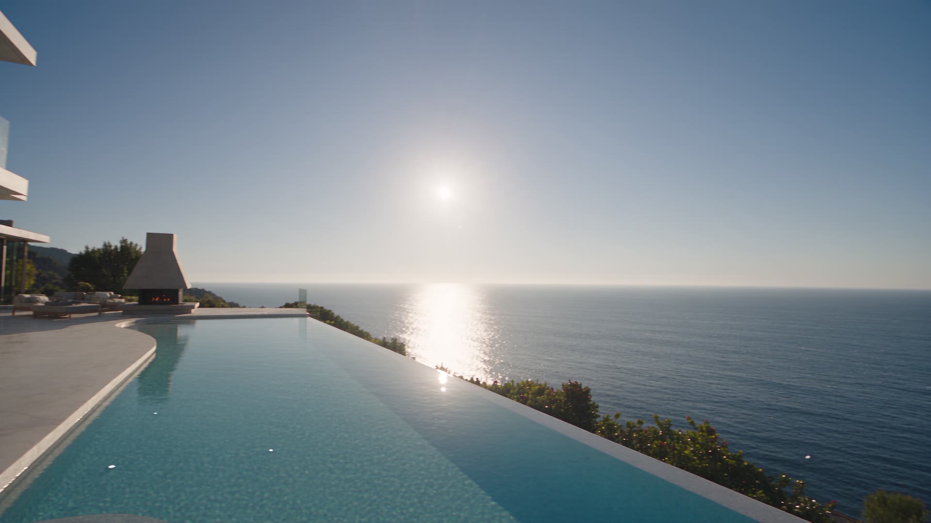 Sunlit oceanfront estate with an infinity pool overlooking the sea
